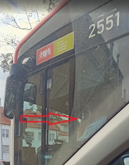 Telefon w ręku kierowcy autobusu, ryzyko dla wielu osób.